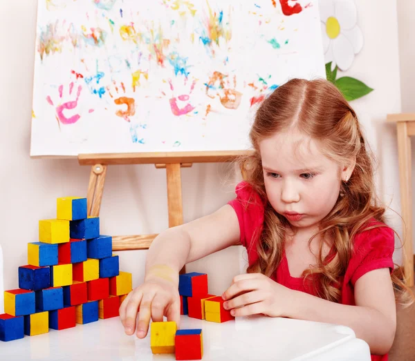 Child with wood block and construction set in play room. — Stock Photo, Image