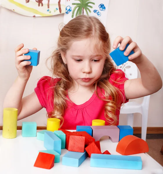 Child with wood block in play room. — Stock Photo, Image