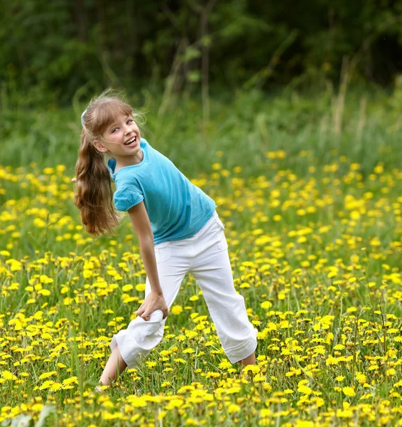 Meisje op gras in bloem op aard. — Stockfoto