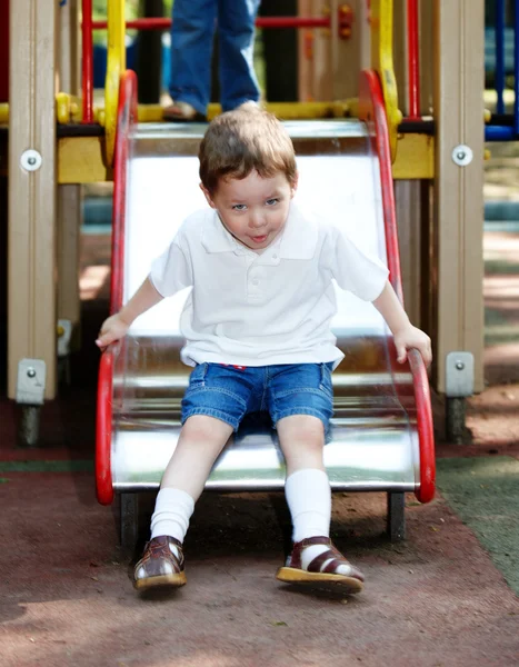 Niño en diapositiva al aire libre en el parque . — Foto de Stock