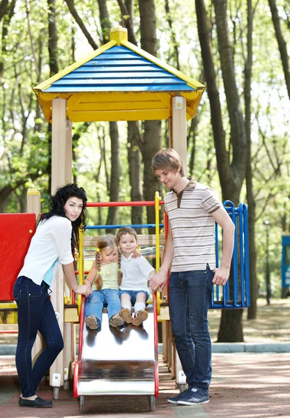 Família com crianças no slide ao ar livre . — Fotografia de Stock