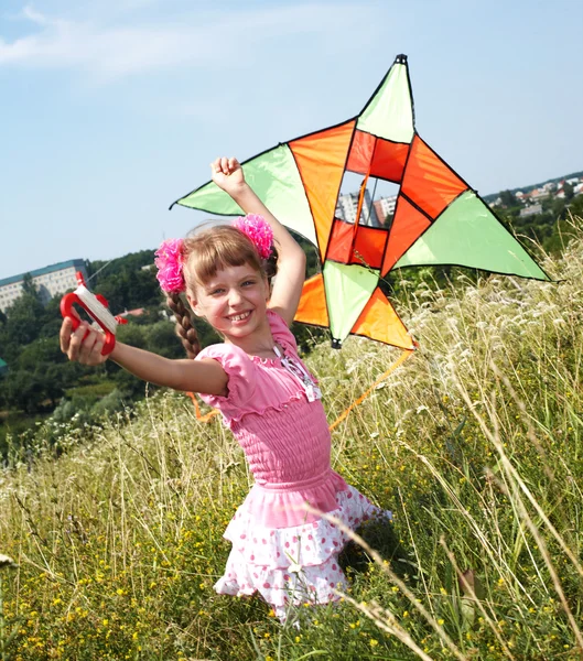 女孩在绿草中的飞的风筝. — 图库照片