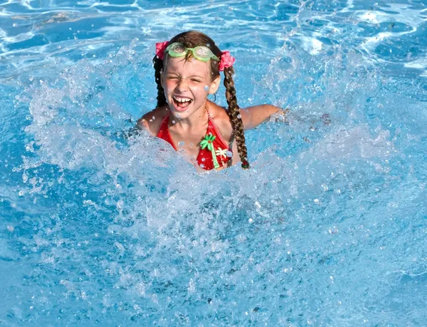 Meisje met rode zwembroek spetteren in zwembad. — Stockfoto