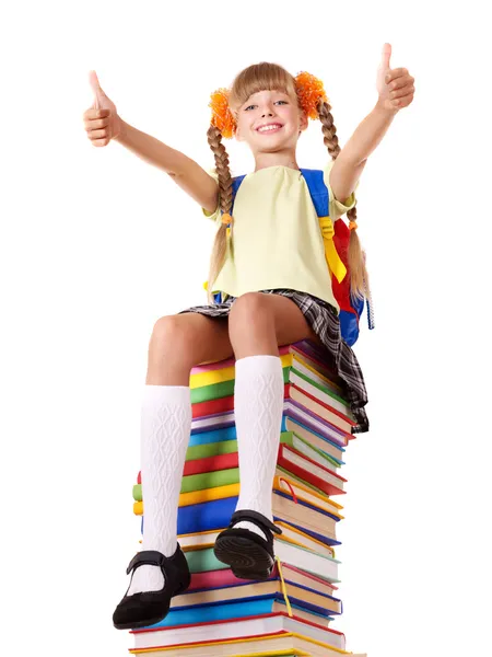 Chica sentada en un montón de libros mostrando los pulgares hacia arriba . — Foto de Stock