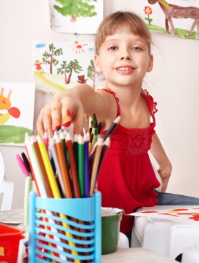 Child drawing colour pencil in preschool.