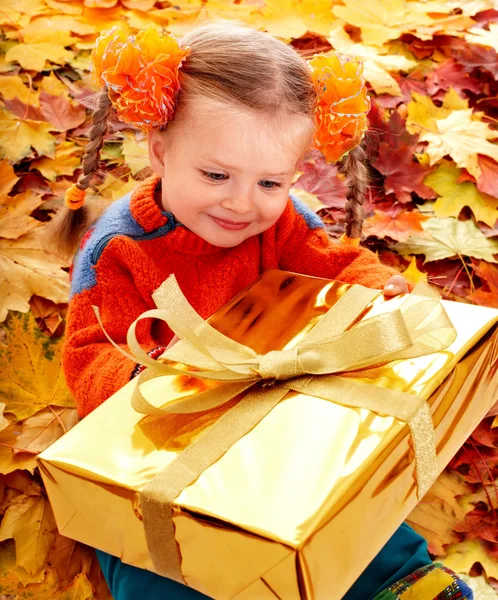 Child girl in autumn orange leaf and gift box. — Stock Photo, Image