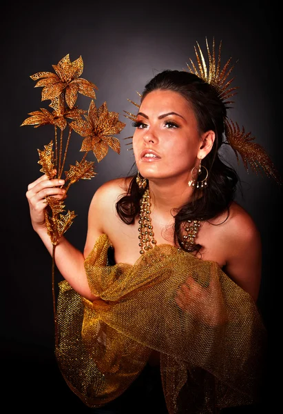 Junge Frau mit goldener Blume auf grauem Hintergrund. — Stockfoto