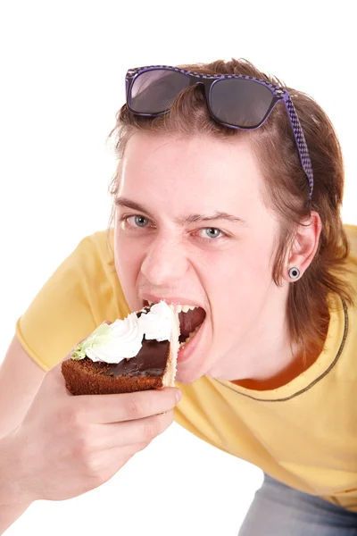 Junger Mann isst Schokoladenkuchen. — Stockfoto