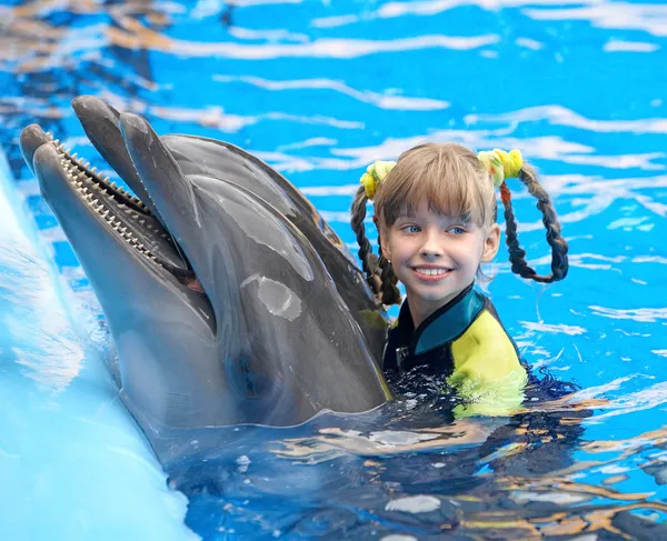 Kind und Delfin im blauen Wasser. — Stockfoto