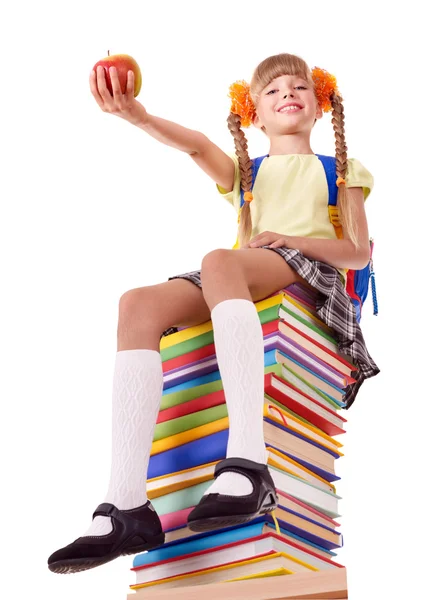 Schoolmeisje zittend op stapel boeken. — Stockfoto