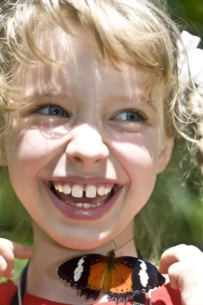 Glückliches Kind mit Schmetterling am Hals. — Stockfoto