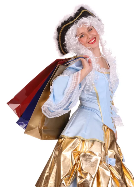 Vrouw in periode jurk met shopping tassen. — Stockfoto