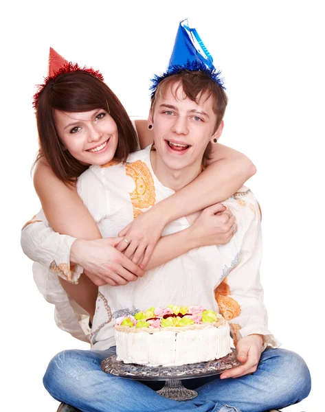 Дівчина в капелюсі на день народження цілує чоловіка з тортом . — стокове фото