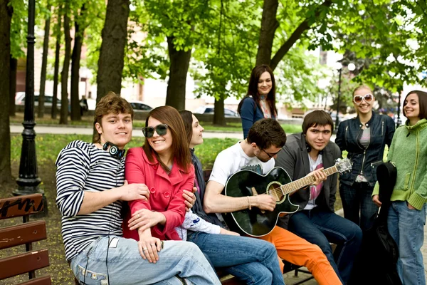 Groep in de stad park luisteren muziek. — Stockfoto