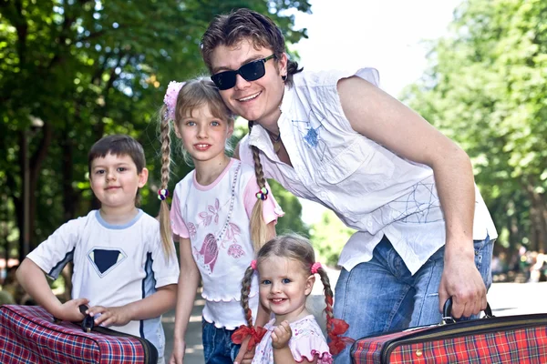 Vader en drie kinderen in park met geval. — Stockfoto