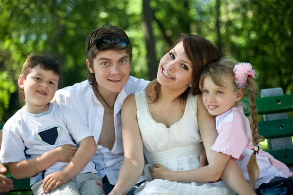 Семья и дети на скамейке в парке . — стоковое фото