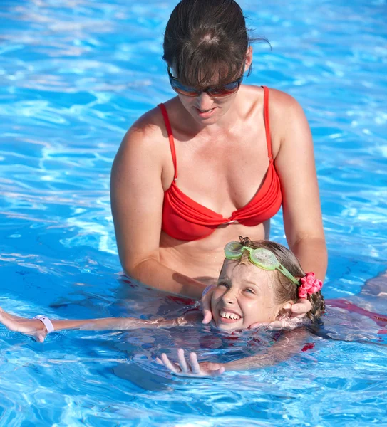 Criança aprende a nadar na piscina com professor . — Fotografia de Stock