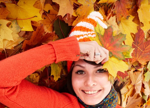 Mädchen im Herbst orange Hut auf Blatt-Gruppe. — Stockfoto