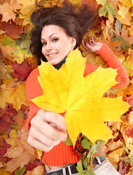 Menina em laranja na folhagem de outono com folha amarela . — Fotografia de Stock