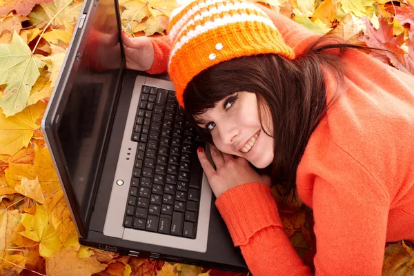 Meisje in herfst oranje bladeren met laptop.fall verkoop. — Stockfoto