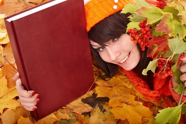 Fille en automne feuilles orange avec livre . — Photo
