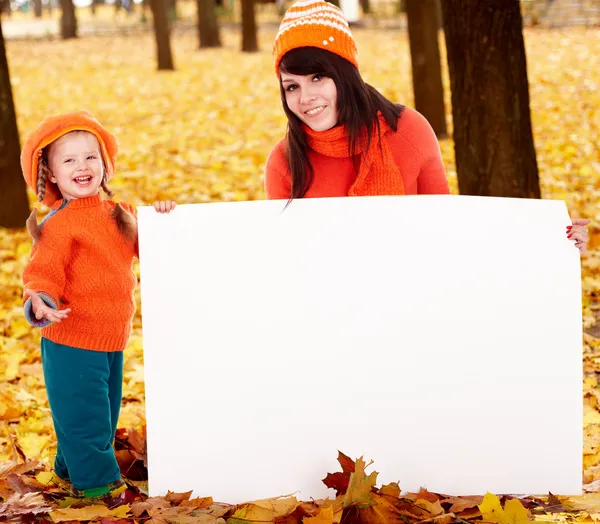 Famiglia felice, bambino sulla foglia d'arancio autunnale con striscione . — Foto Stock