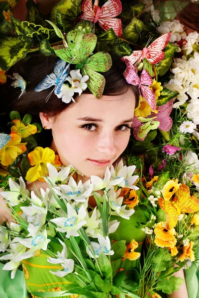 Красивая девушка с бабочкой и цветами на траве . — стоковое фото