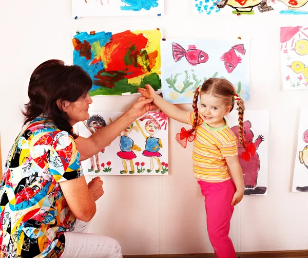 Niño con el maestro dibuja pinturas en la sala de juegos . — Foto de Stock