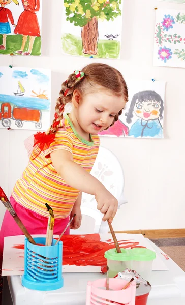 Kind met beeld en penseel in de speelkamer. — Stockfoto