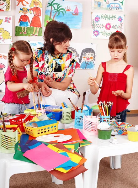 Children with teacher draw paints in playroom. — Stock Photo, Image