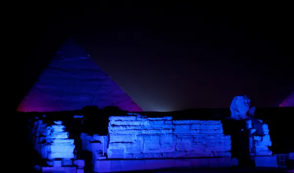 Färgade lampor ljus sphinx och pyramider — Stockfoto