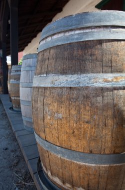 Barrels by old saloon in San Diego clipart