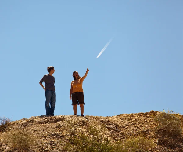 Туристи в пустелі вказують на літальний трейл — стокове фото