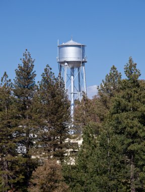 Water tower peeps above tree line clipart