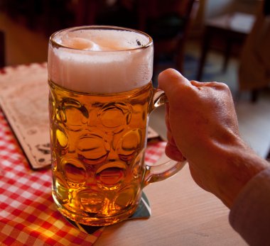 Liter glass of beer in hand clipart