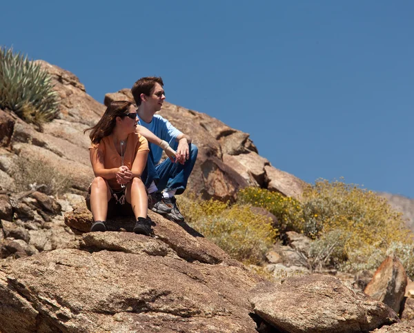 Hikers in desert look at distant object — Stock Photo, Image