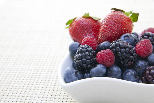 Berries in a bowl on a placemat — Stock Photo, Image