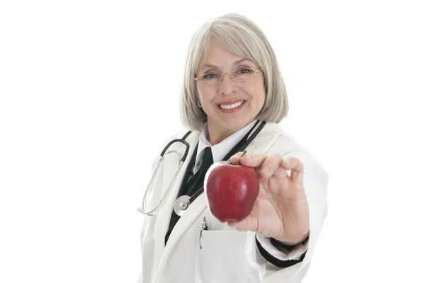 Зріла жінка-лікар тримає яблуко — стокове фото