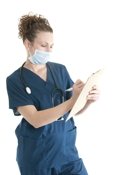 Krankenschwester schreibt auf Klemmbrett — Stockfoto