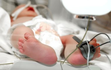 Newborn baby foot in incubator clipart