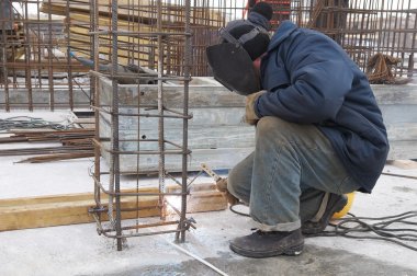 Worker welding a metal lattice at construction s clipart