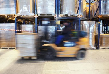 Forklift in motion at warehouse clipart