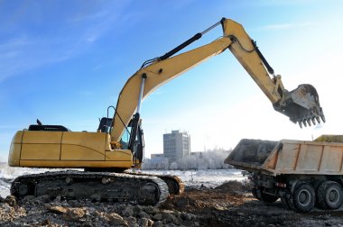 Loader excavator loading a rear-end tipper clipart