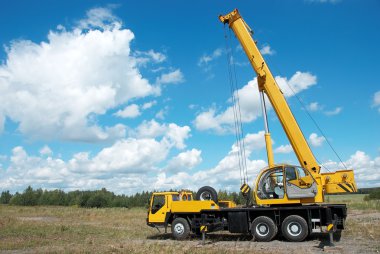 Mobile crane with risen boom outdoors clipart