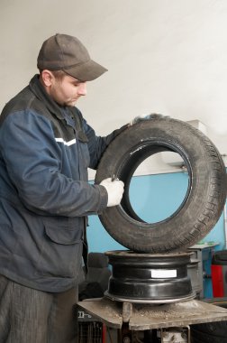 Repairman lubricating car tyre clipart