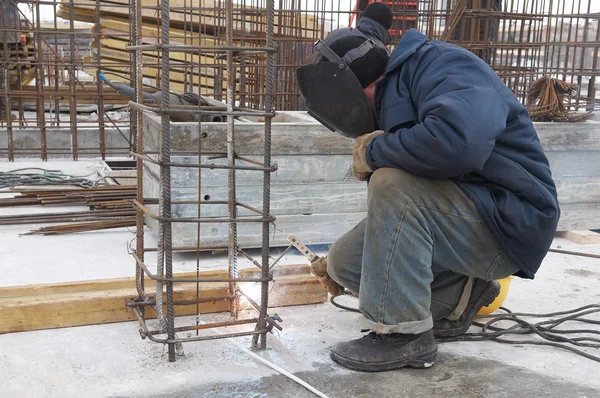 Trabajador soldando una rejilla de metal en la construcción s — Foto de Stock