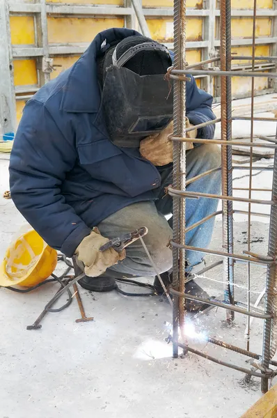 Arbeiter schweißt ein Metallgitter am Bau — Stockfoto