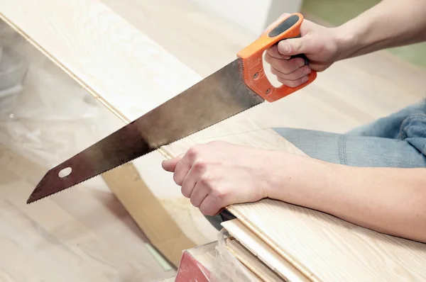 Hand saw cutting a board — Stock Photo, Image