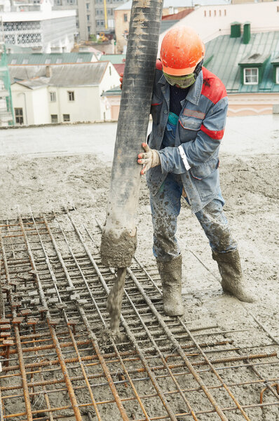 Builder worker pouring concrete into form