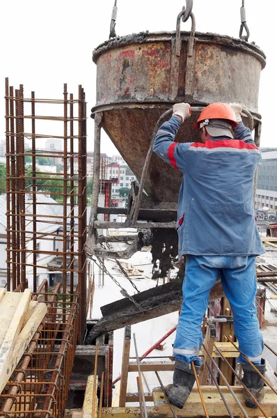 Trabalhadores da construção civil derramando concreto em forma — Fotografia de Stock